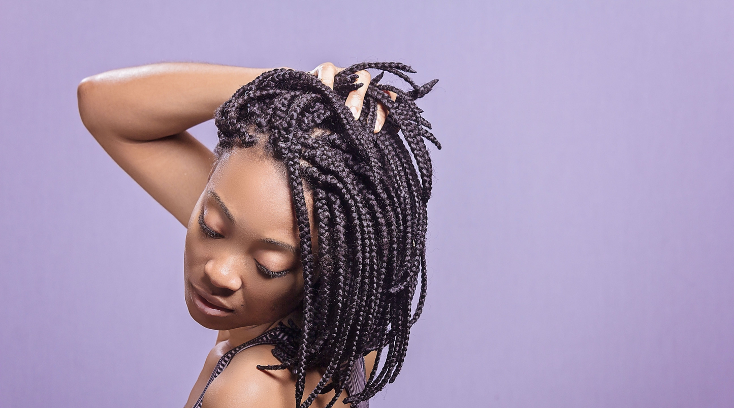 woman running hands through braided protective hairstyle