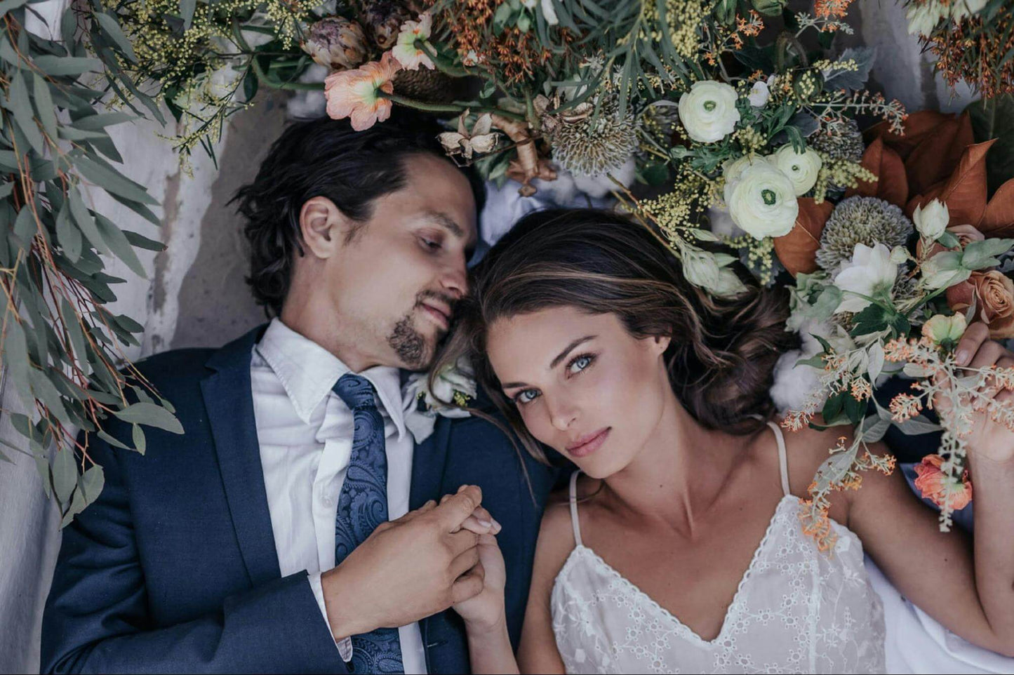 Bride and Groom Lying On A Bed Of Flowers